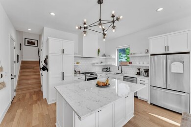 Kitchen with white cabinets, open shelves, stainl