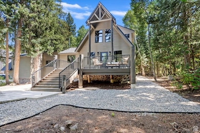 Back of property featuring a deck, stairs, a metal roof, and a standing seam roof