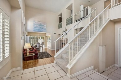 Entryway with a high ceiling, baseboards, and wood