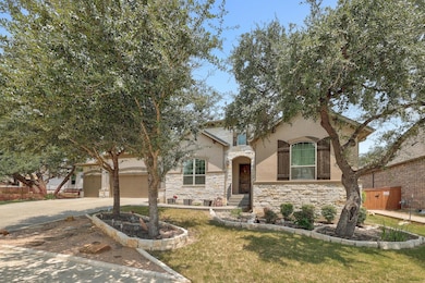 View of front of house featuring stone siding, concrete driveway, a front yard, stucco siding, and a garage