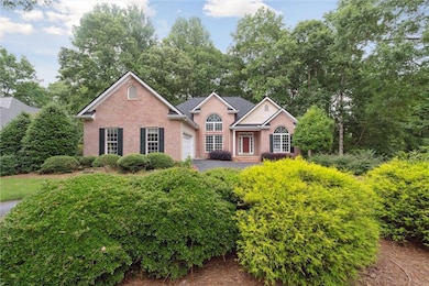 View of front of property with brick siding and view of scattered trees