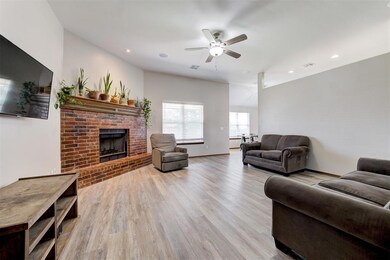 Living area featuring wood finished floors, a ceiling fan, a brick fireplace, recessed lighting, and baseboards