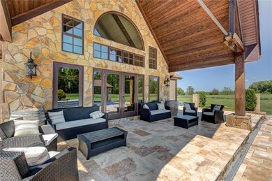 Covered patio with travertine decking overlooking pool.  Great for entertaining
