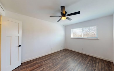 Unfurnished room with ceiling fan and dark hardwoo
