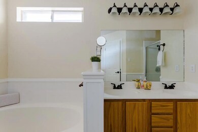 Bathroom featuring a garden tub, double vanity, a