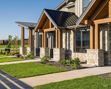 Property entrance with stone siding, a metal roof, and a lawn