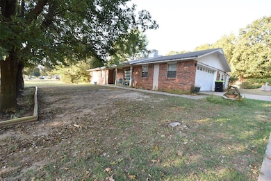 View of front of house featuring brick siding, a chimney, and an attached garage