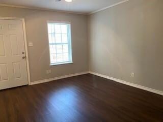Foyer entrance featuring crown molding and dark wood-type flooring