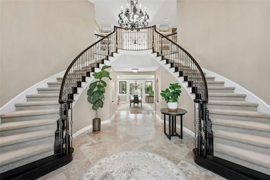 Foyer featuring stairs, a chandelier, a towering 