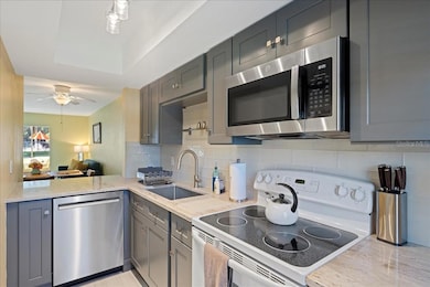 The updated kitchen boasts solid wood shaker-style cabinets, granite countertops, a large farmhouse sink, and a tasteful tile backsplash in clean, modern colors. A convenient pass-through to the dining area provides the perfect spot to pull up a stool for a quick, casual meal.