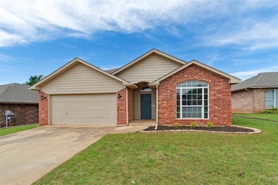Single story home with an attached 2 car garage, brick siding, and driveway