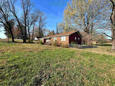 View of property exterior with fence and a yard