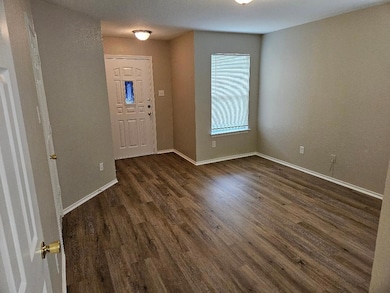 Foyer with dark wood finished floors and baseboar