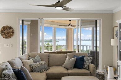 Living room featuring ceiling fan, a water view, a