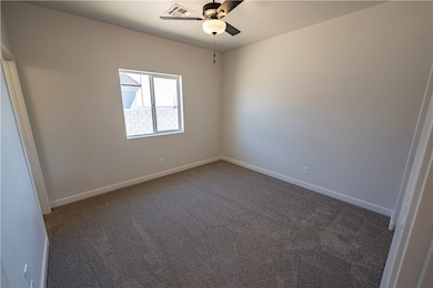 Empty room featuring carpet floors, ceiling fan, a