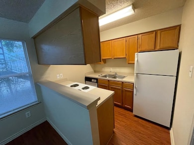 Kitchen with a sink, white appliances, light coun