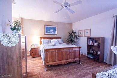 Bedroom with ceiling fan, lofted ceiling, and hard