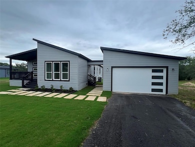 View of front of home with a front yard and driveway