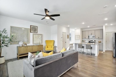 Living room with wood-type flooring and ceiling fan