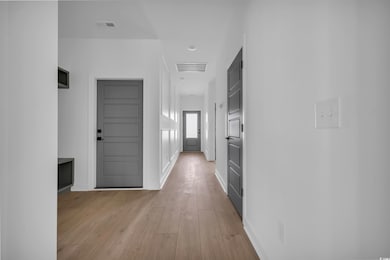 Corridor with light wood-type flooring and baseboards