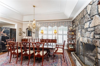 This large separate dining room features tray ceiling, bold, yet warm granite wall with gas fireplace.