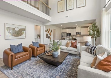 Living room featuring a high ceiling, light wood-style floors, and plenty of natural light