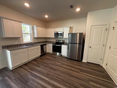 Kitchen featuring white cabinetry, stainless steel
