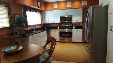 The eat-in kitchen boasts granite countertops, bam