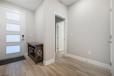 Foyer entrance with wood finish floors and baseboa