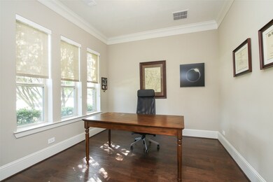The study's glass French doors makes for a private setting.   Notice the wood floors and pull down shades.