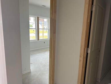 Hallway featuring baseboards and concrete floors