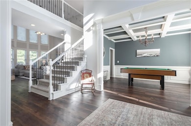 Game room featuring billiards table, a chandelier, dark wood finished floors, coffered ceiling, and beam ceiling