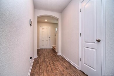 Foyer entrance with archway and wood laminate floo
