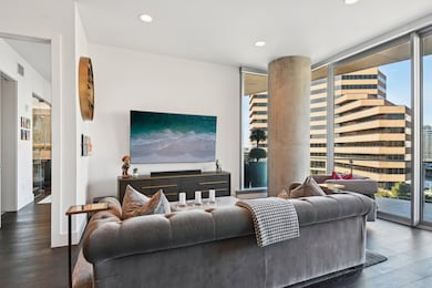 Living room with a wall of windows and dark wood-type flooring