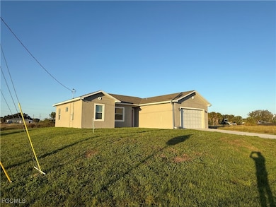 Single story home featuring stucco siding, driveway, a front yard, and a garage