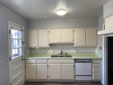 Kitchen featuring dishwasher, a sink, light countertops, and tasteful backsplash