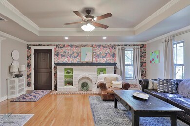 Living room featuring crown molding, a brick firep