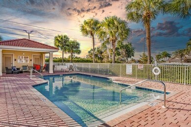 Pool at dusk with a community pool, fence, and a p