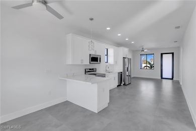 Kitchen with kitchen peninsula, white cabinets, an