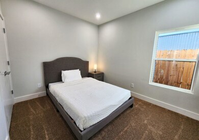 This bedroom features neutral walls, a cozy bed wi