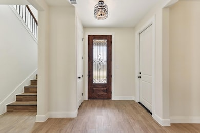 Foyer with stairway, light wood-style flooring, v