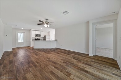 Unfurnished living room featuring dark hardwood /
