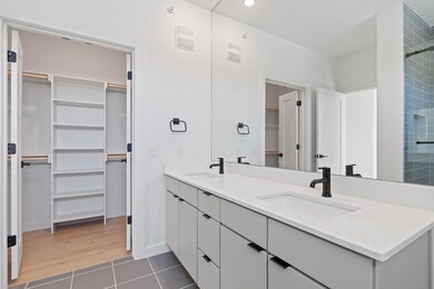 Full bathroom with double vanity, a spacious clos