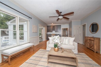 Living room featuring crown molding, ceiling fan,