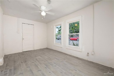 Unfurnished room with a smoke detector, light wood-style flooring, and a ceiling fan