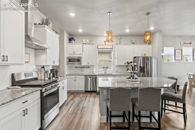 Kitchen with wall chimney range hood, a kitchen br