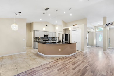Kitchen featuring hanging light fixtures, backsplash, appliances with stainless steel finishes, high vaulted ceiling, and recessed lighting