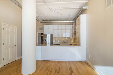 Kitchen with white cabinetry, tasteful backsplash,