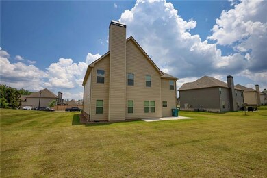 Rear view of house featuring a patio, a lawn, and a chimney