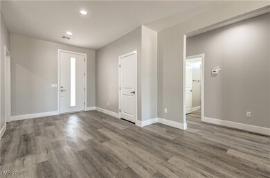 Foyer entrance with visible vents, baseboards, woo